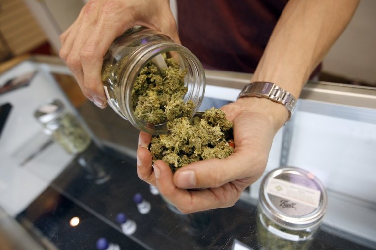 A budtender pours marijuana from a jar at Perennial Holistic Wellness Center medical marijuana dispensary, which opened in 2006 in Los Angeles, Califo...
