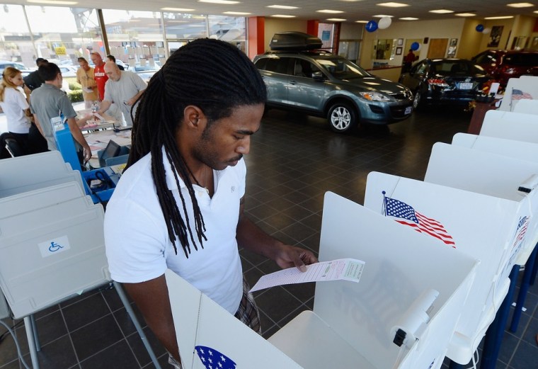 William Barney, 27, holds his ballot after voting in the US presidential election at the polling place of Star Mazda car dealership on Tuesday, Nov. 6, in Glendale, Calif.