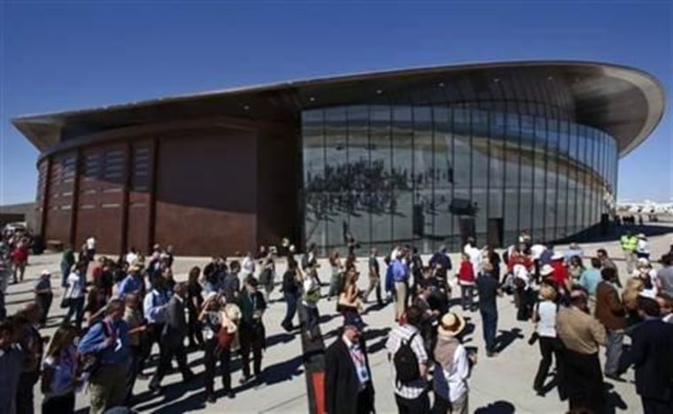 Guests stand outside the new Spaceport America hangar in Upham, N.M., in this Oct. 17, 2011 file photo. Gov. Susana Martinez Tuesday May 7,2013 announced that Elon Musks' Space Exploration Technologies, or SpaceX, has signed a three-year lease to do testing of its "Grasshopper" reusable rocket in southern New Mexico, adding a second company at Spaceport.