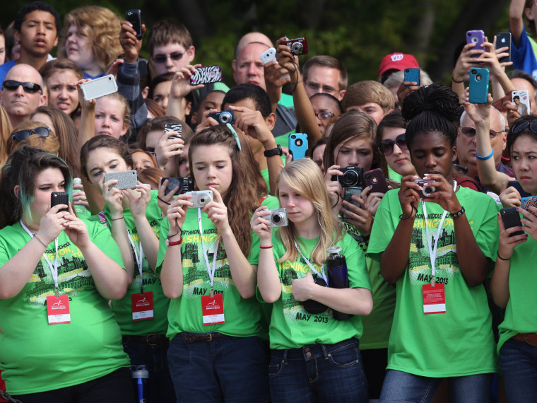 Young girls take pictures as they wait for Prince Harry to arrive at Arlington National Cemetery.