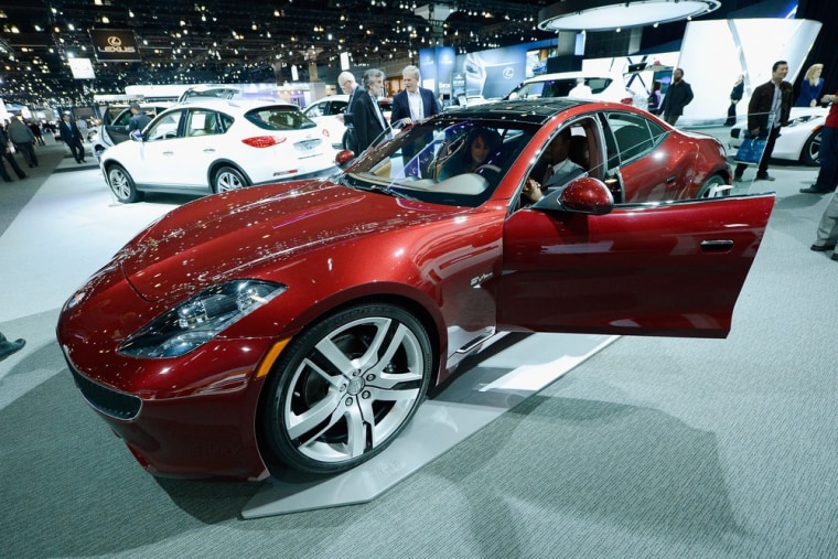 Reporters gather around a Fisker Karma during the Los Angeles Auto show on November 29, 2012 in Los Angeles, California.