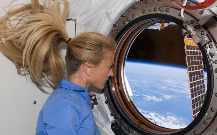 NASA astronaut (and quilter) Karen Nyberg looks out the window of the Japanese Kibo laboratory on the International Space Station in 2008.