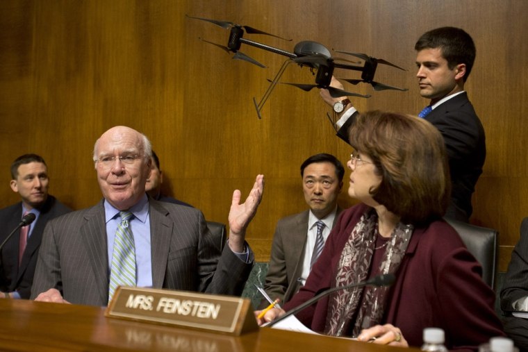 Senate Judiciary Committee Chairman Sen. Patrick Leahy, D-Vt., left, gestures to an example of a drone held by a staff member, on Capitol Hill in Wash...
