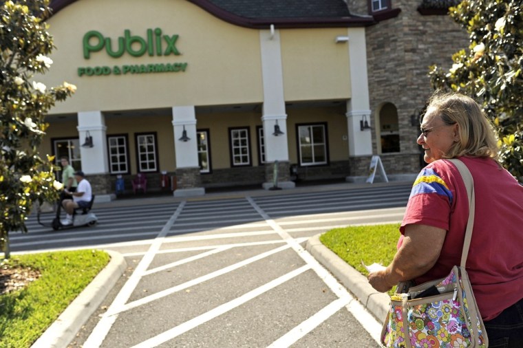 Clutching the Powerball tickets that she estimates she won $8 on, Denise Godsey looks over at a gaggle of gathered television news trucks at a Publix in Zephyrhills, Fla.