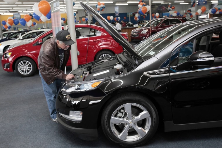 A potential customer looks under the hood of a black 2012 Chevrolet Volt electric car in the showroom of George Matick Chevrolet auto sales in Redford...