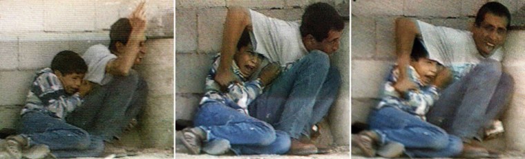 A September 30, 2000, file combo of TV grabs from France 2 footage taken during Israeli-Palestinian clashes in Netzarim in the Gaza Strip shows Jamal al-Dura and his son Mohammed, 12, hiding behind a barrel from Israeli-Palestinian cross fire.