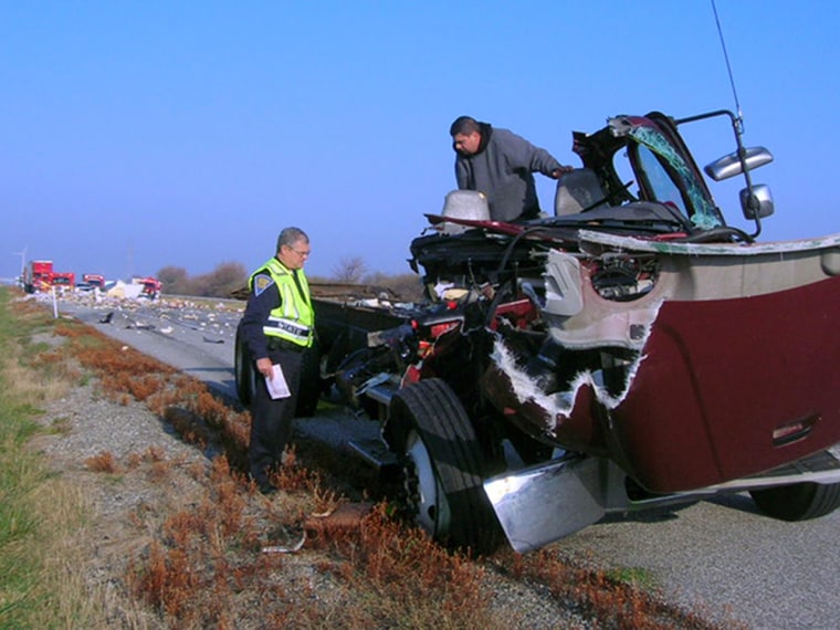 Motor Carrier Inspector Master Trooper Mike Probasco, left, looks over the remains of a box truck with its driver Dagoberto Perez, of Cicero, Ill. in November 2010. Perez, who said he fell asleep and veered off the road, was cited for being a fatigued driver. Both drivers received non-life threatening injuries.