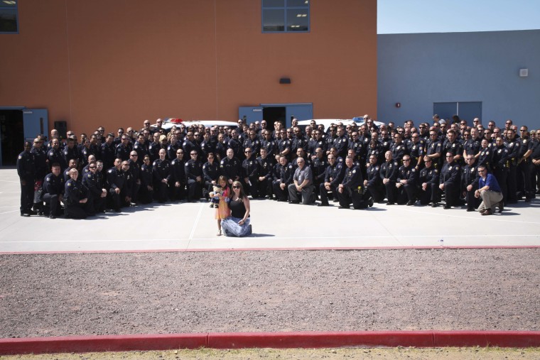 Phoenix Police Department officer with 5-year-old Tatum, her mother, Stephanie Raetz, on the morning of the girl's graduation from kindergarten.