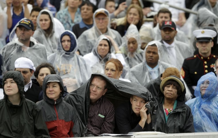 Guests sit in the stands in the rain during the commencement ceremonyfor the United States Naval Academy in Annapolis. President Barack Obama urged new graduates to exhibit honor and courage in tackling incidents of sexual assault as they assume leadership positions in the military.