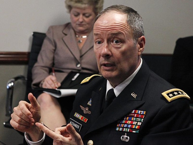 An aide (L) takes notes as U.S. General Keith Alexander, director of the National Security Agency (NSA) and U.S. Cyber Command, speaks to reporters du...