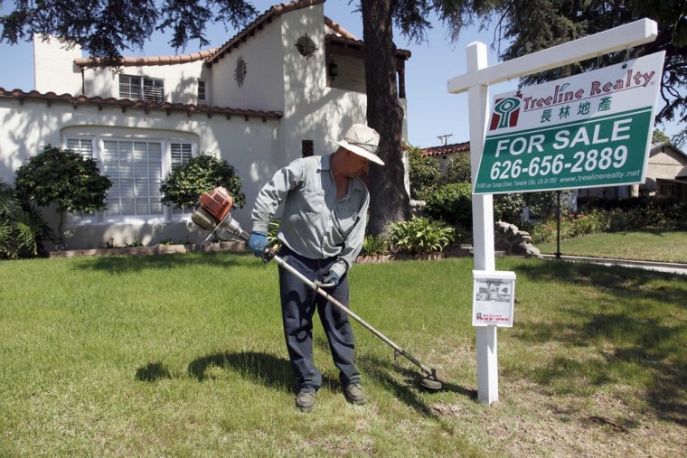In this Monday, May 13, 2013 photo, gardener Jose Lopez trims the front lawn of a home for sale in Alhambra, Calif.