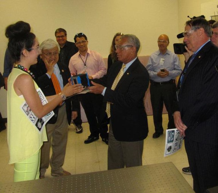 Sarah Hovsepian, manager of the SpaceShop fabrication lab at NASA's Ames Research Center, gives NASA chief Charles Bolden a ceremonial cubesat during his tour of Ames on Friday. To the left of Bolden is Rep. Mike Honda, D.-Calif.; to the right is Ames Director Pete Worden.