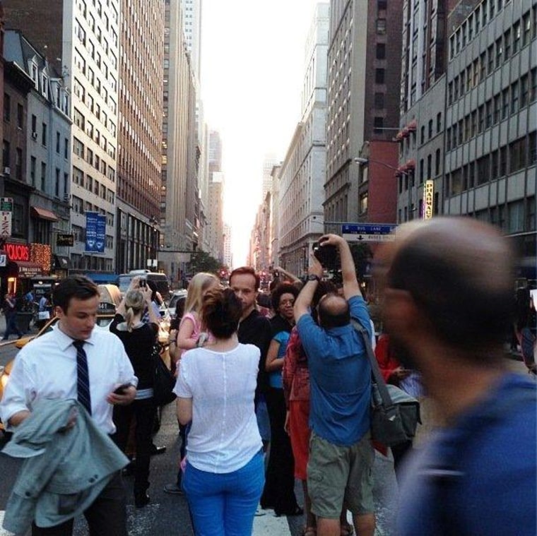 Sun-watchers gather in the middle of Manhattan's 34th Street, waiting for the sun to go down.