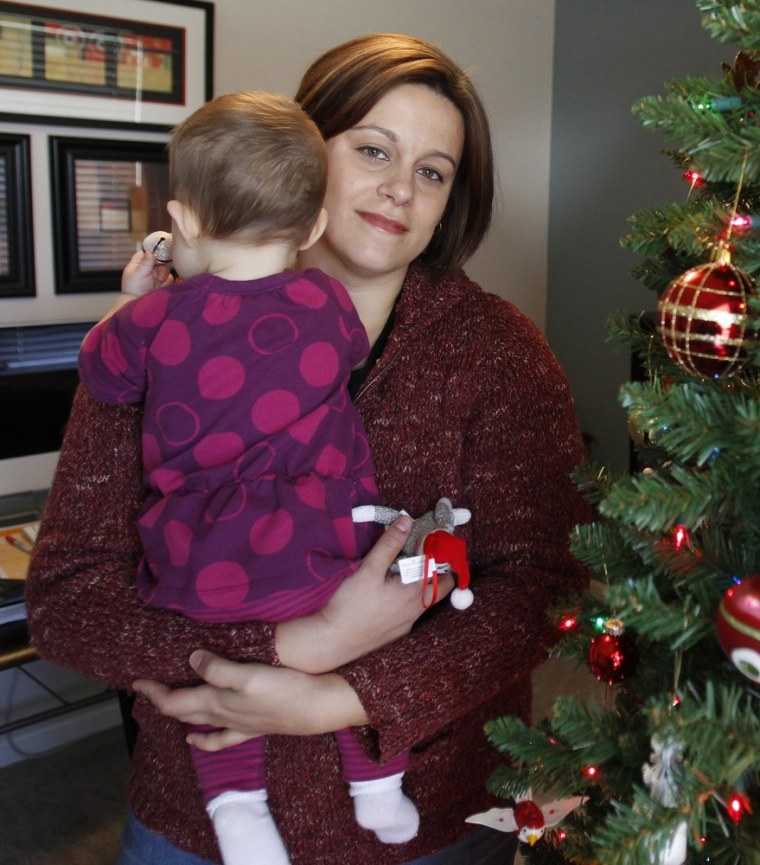 Christa Dias holding her daughter, then 11 months old, in her Withamsville, Ohio home in Dec., 2011.