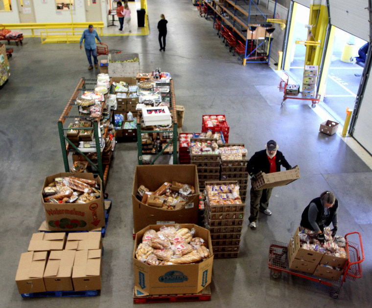 Volunteers gather food at the New Hampshire Food Bank in Manchester, N.H., to be delivered around the state