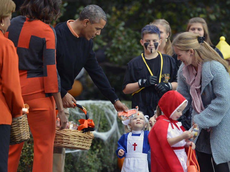 epa03931793 US President Barack Obama (C), First Lady Michelle Obama and her mother Marian Robinson (L) welcome treat-or-treating local children and c...