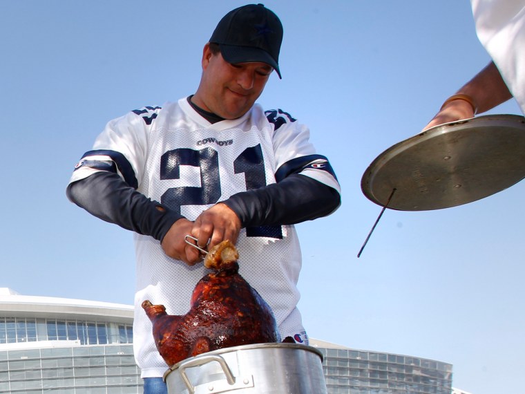 More men are taking on the turkey this year, and deep-frying is one method that tends to be their domain. Here, Joey Tidwell of San Marcos, Texas, checks on the status of his fried turkey outside of Cowboys Stadium before an NFL football game against the Miami Dolphins  in this Nov. 24, 2011 file photo.
