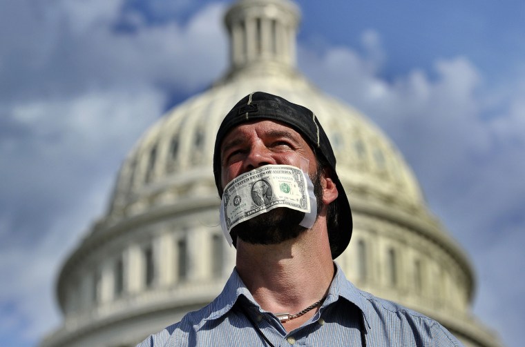 A protester covers his mouth with a dollar bill