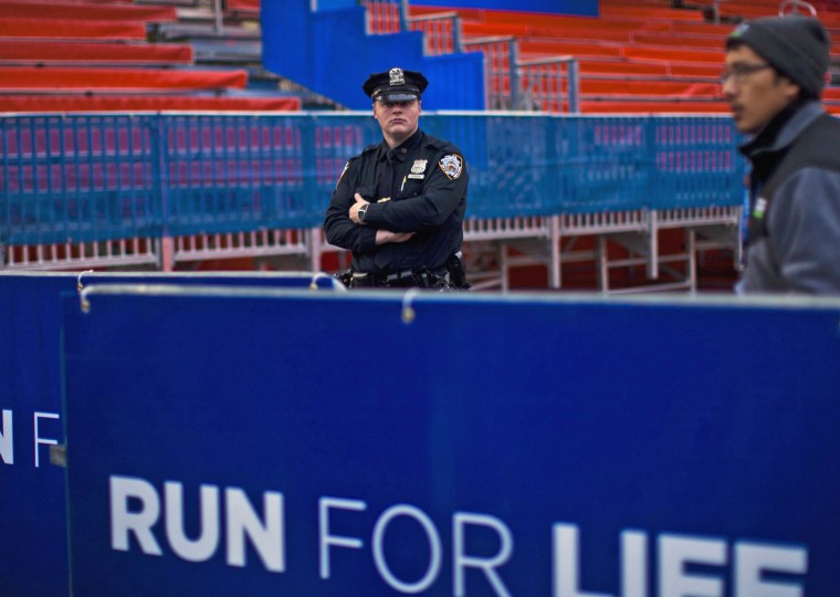 A New York City police officer stands guard during the ceremonial painting of the New York City Marathon blue line at Central Park on Wednesday.