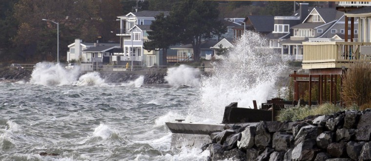 Windblown waves coming in off Puget Sound close to high tide batter waterfront homes in Seattle's West Seattle neighborhood on Saturday.
