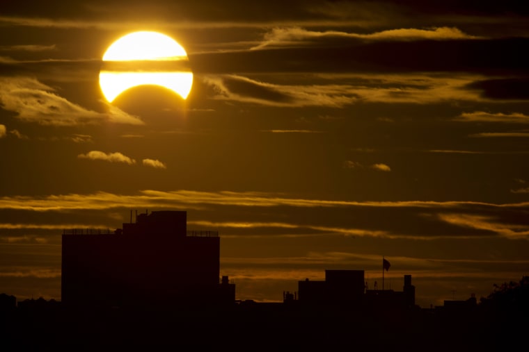A partial Solar eclipse is seen just after sunrise over the Queens borough of New York across the East River on Nov. 3, 2013 in New York.