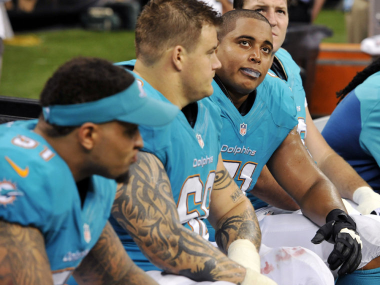 Miami Dolphins guard Richie Incognito (68) and tackle Jonathan Martin (71) look up from the bench in the second half of an NFL football game against t...