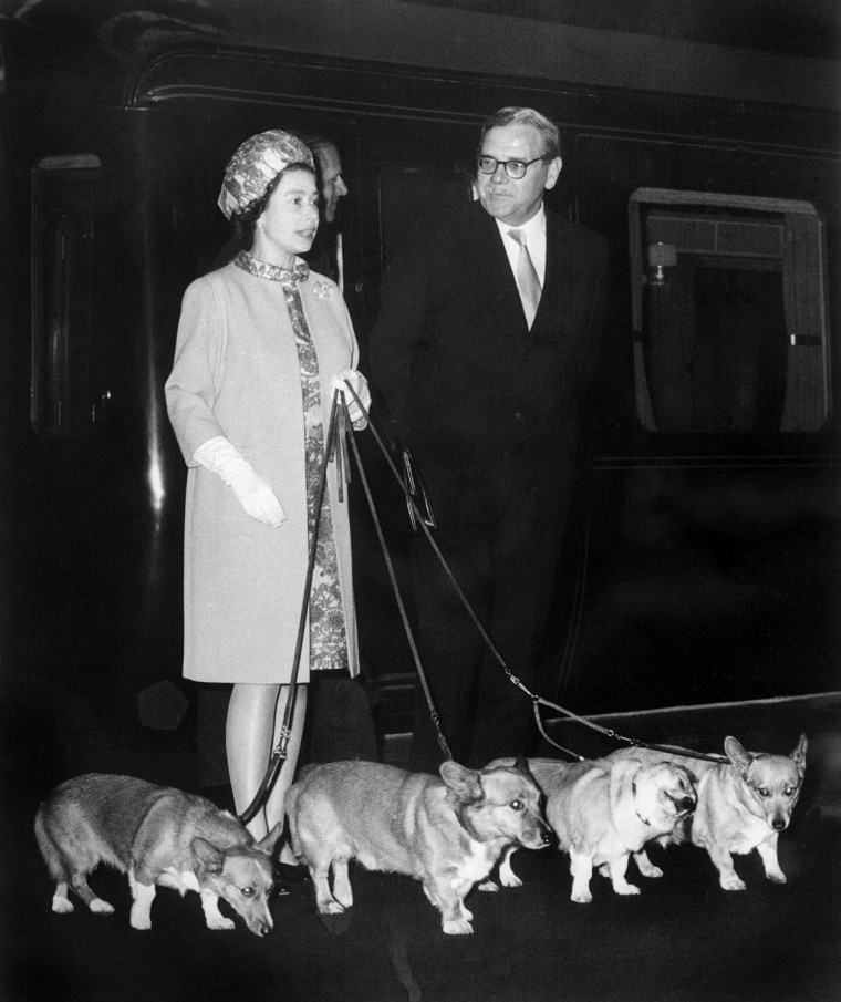 Image: Queen Elizabeth II, left, arrives at King's Cross railway station in London with her four Corgi dogs on Oct. 15, 1969.