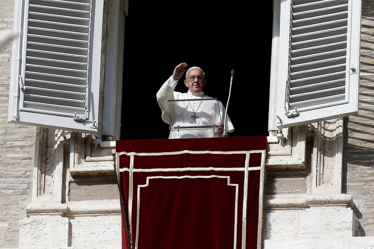 Pope Francis waves to the faithful from a window of the Apostolic Palace during the Angelus prayer in Saint Peter's Square.