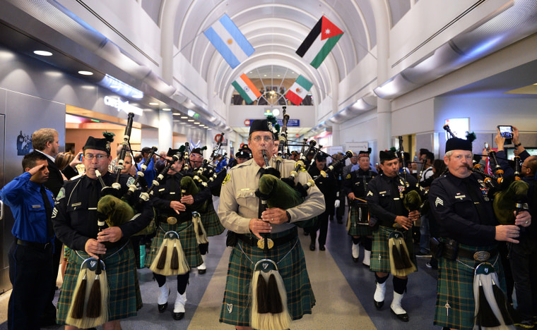 Bagpipe players march through Terminal 4 at LAX with the U.S. Honor Flag as it arrives at the airport.