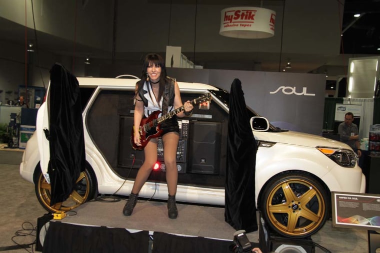 Rocker Leona X is seen here with the Kia Soul at the 2013 SEMA Show in Las Vegas. The auto industry is adapting to a younger generation of car buyers for whom customization is key.
