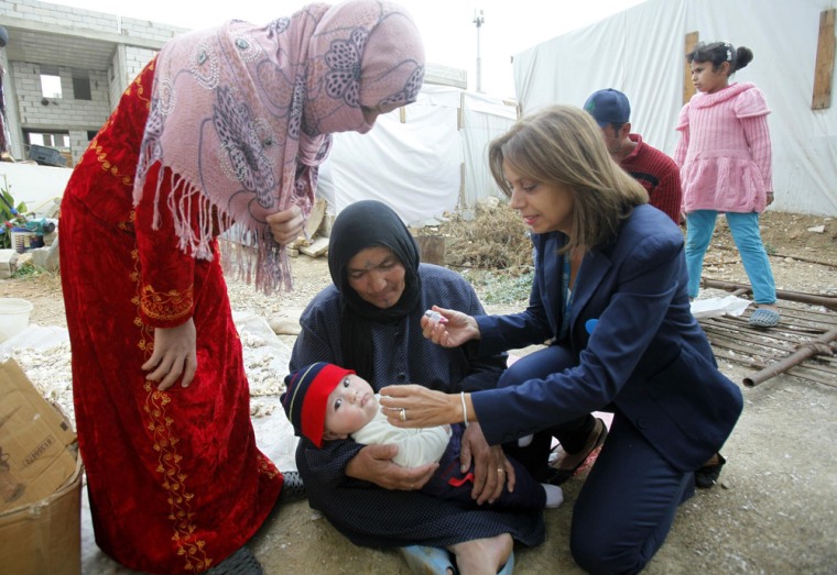 Annamaria Laurini, UNICEF Representative in Lebanon, administers a polio vaccine to a baby on Nov. 8, 2013, at a Syrian refugee camp near Zahle town in the Bekaa Valley in Lebanon.