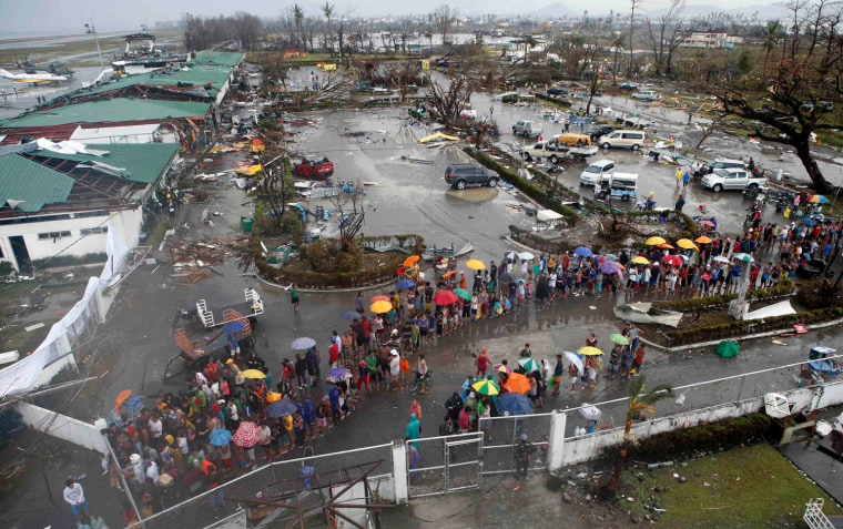 Typhoon victims queue for food and water outside the airport of Tacloban city in central Philippines Nov. 10, 2013.