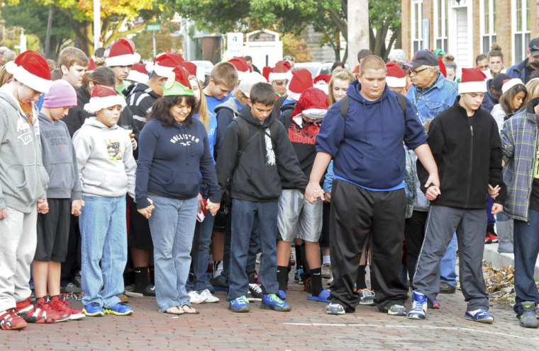 Members of the Port Clinton, Ohio, community pause for a moment of silence on Oct. 28, 2013, during a ceremony for Devin Kohlman outside his home.