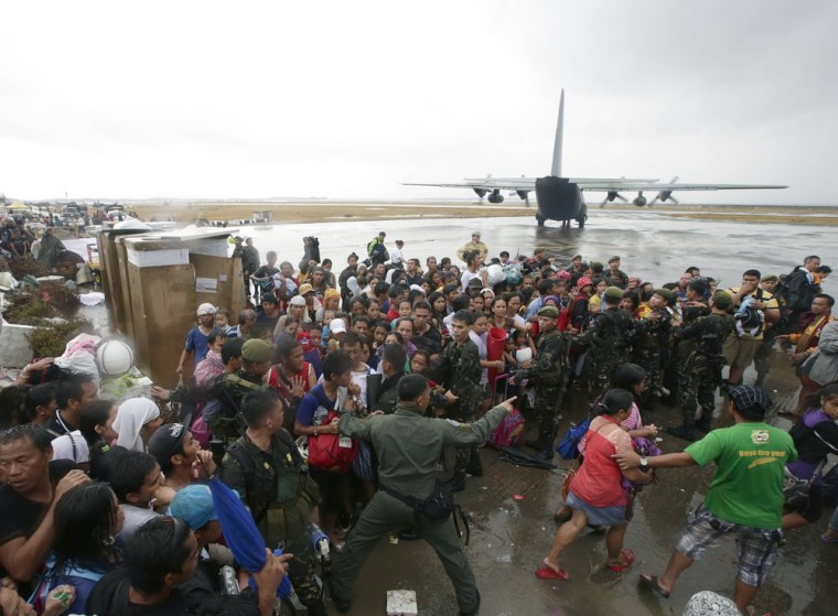 Typhoon survivors rush to get a chance to board a C-130 military transport plane in Tacloban, Philippines, on Tuesday.