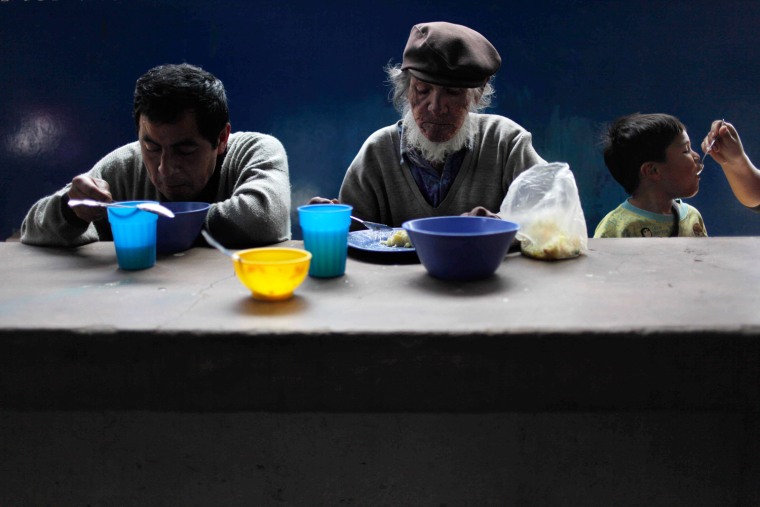 Juan Barrueta, center, eats his lunch in a soup kitchen in Lima, Peru, on Sept. 5, 2013.