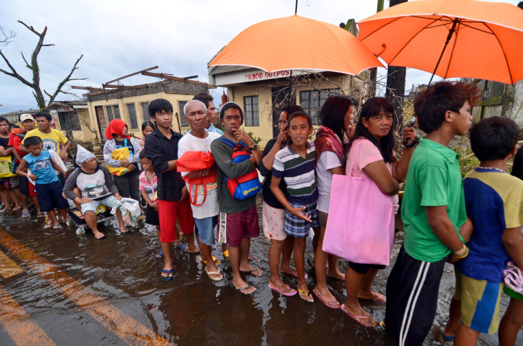 Survivors wait in line to recieve relief goods Tuesday in an area devastated by Typhoon Haiyan in Leyte, Philippines.