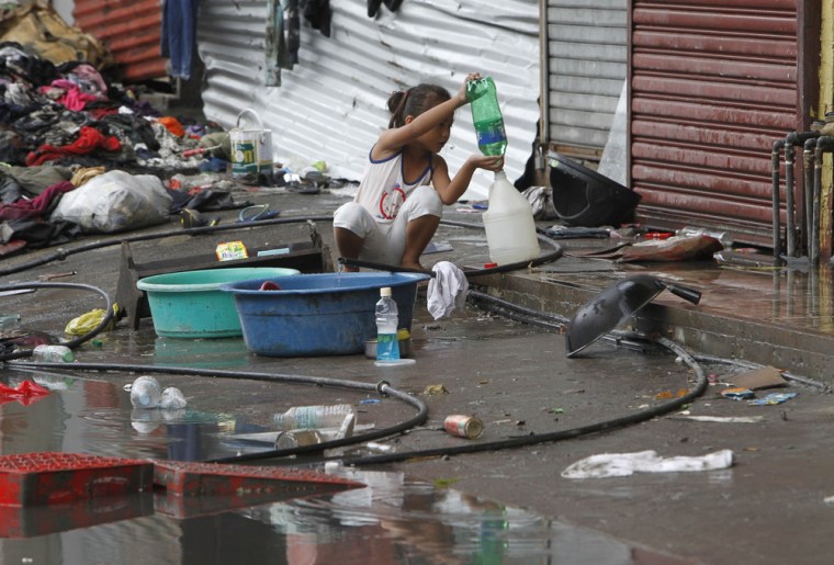 A girl transfers drinking water she collected from a faucet after Typhoon Haiyan devastated Tacloban city, central Philippines November 12, 2013. Resc...