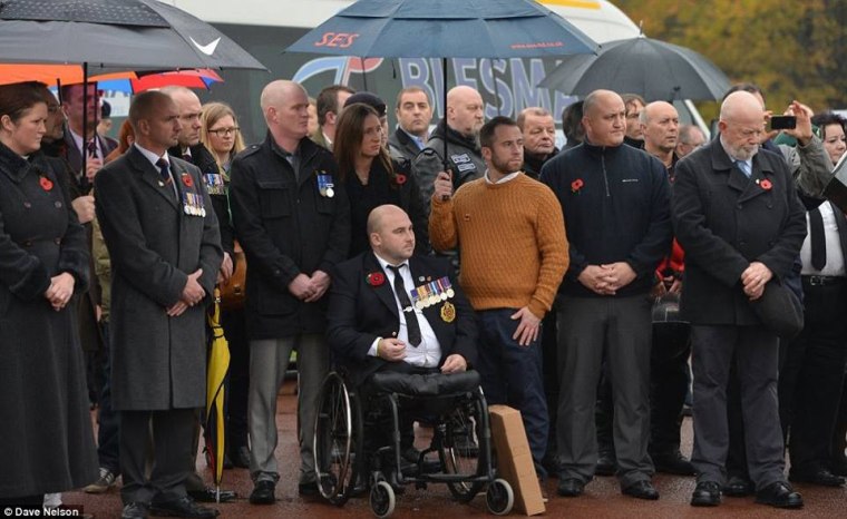 Rick Clement, joined by friends and veterans, pays his respects to WWII veteran Harold Percival.