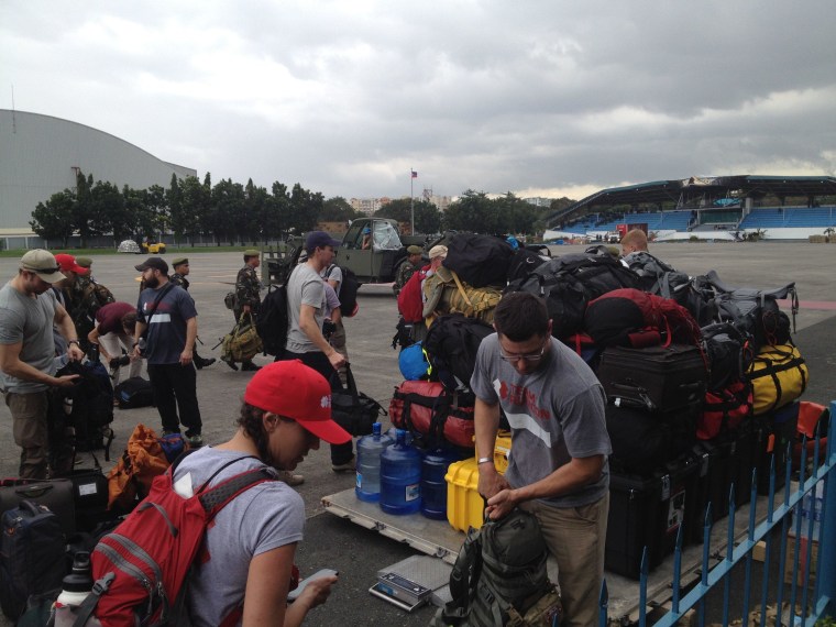 U.S. veterans, now volunteers for Team Rubicon, load up supplies at an airfield in Manila, ultimately bound for a field hospital where scores of injured and ill from the typhoon need care and medicine.
