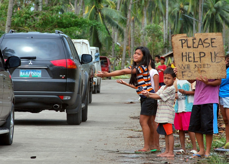Children beg for food from passing motorists in Borbon town, Cebu, Philippines, Nov. 11, 2013.