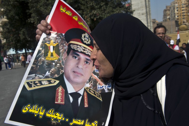 A woman kisses a poster of Gen. Abdel Fattah el-Sissi as she arrives in Tahrir Square to mark the 40th anniversary of the 1973 Arab-Israeli war on October 6, 2013 in the capital Cairo.