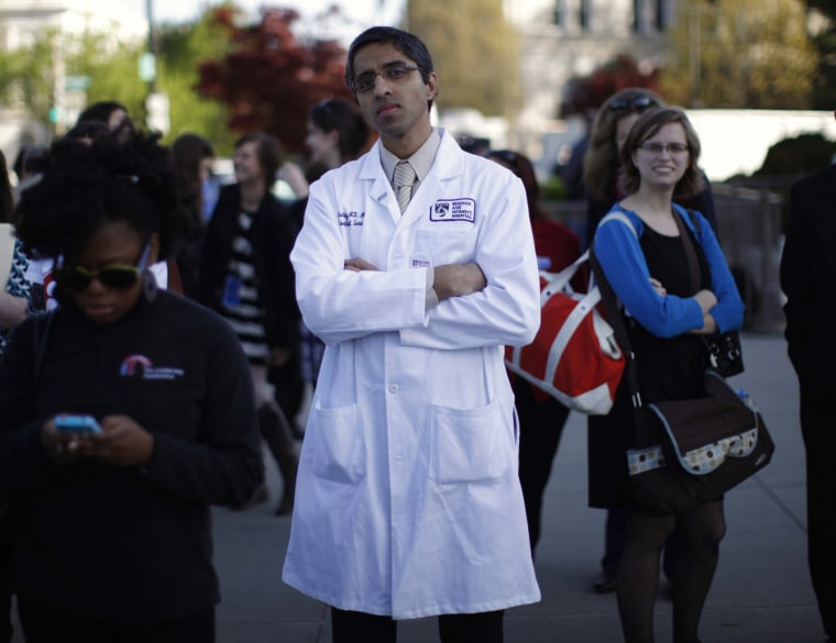 Doctor Vivek Murthy stands among other bystanders during the first day of legal arguments over the Affordable Care Act outside the Supreme Court in Washington, on March 26, 2012.