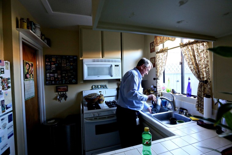 Bret Lane washes out his coffee pot at his home after a shift at a call center in San Diego, Calif., on Oct. 31. Lane was laid off after 16 years as a salesman in telecommunications and was unemployed until he got a job at a call center.