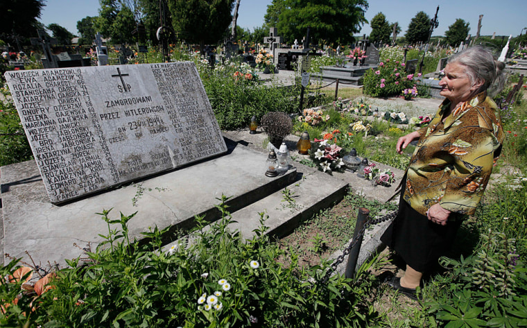 A woman stands near a mass grave and monument in the village of Chlaniow, Poland, that holds the bodies of Poles killed in a 1944 attack on the village by the Nazi SS-led Ukrainian Self Defense Legion on June 19, 2013.