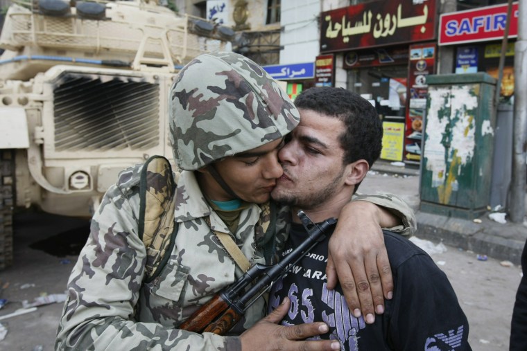 An Egyptian civilian kisses an Army soldier after troops took position at major junctions in central Cairo on January 29, 2011. Thousands of anti-regime demonstrators continue to pour onto Cairo's streets, demanding President Hosni Mubarak stand down the day after the veteran leader ordered the Army to tackle the deadly protests.