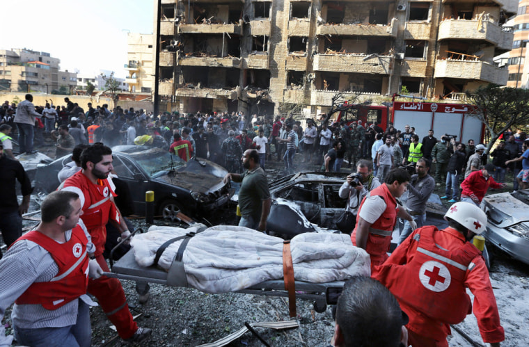 Lebanese Red Cross workers carry a dead body at the scene of explosions near the Iranian Embassy in Beirut, Tuesday.