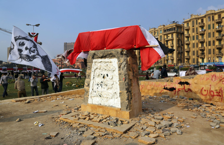 A mock coffin rests on the vandalized pedestal of a memorial dedicated to demonstrators killed in Egypt's 2011 revolutionary turmoil, in Tahrir Square, Cairo, Tuesday.