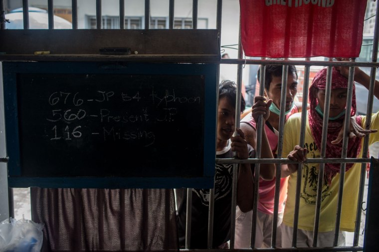 Prisoners look past a sign showing the number of inmates still missing at the Tacloban Jail on November 19, in Leyte, Philippines.