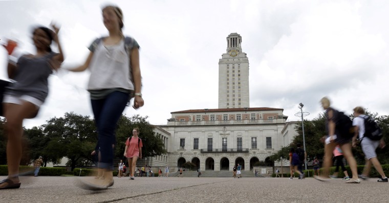 Students walk through the University of Texas at Austin campus near the school's iconic tower in Austin, Texas.