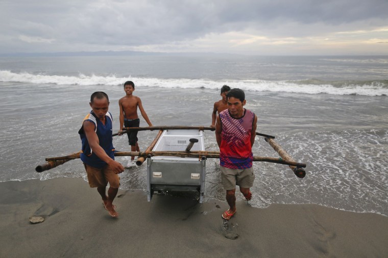 Fishermen carry a boat made from a broken fridge to the beach in Tanauan on Nov. 20, 2013.